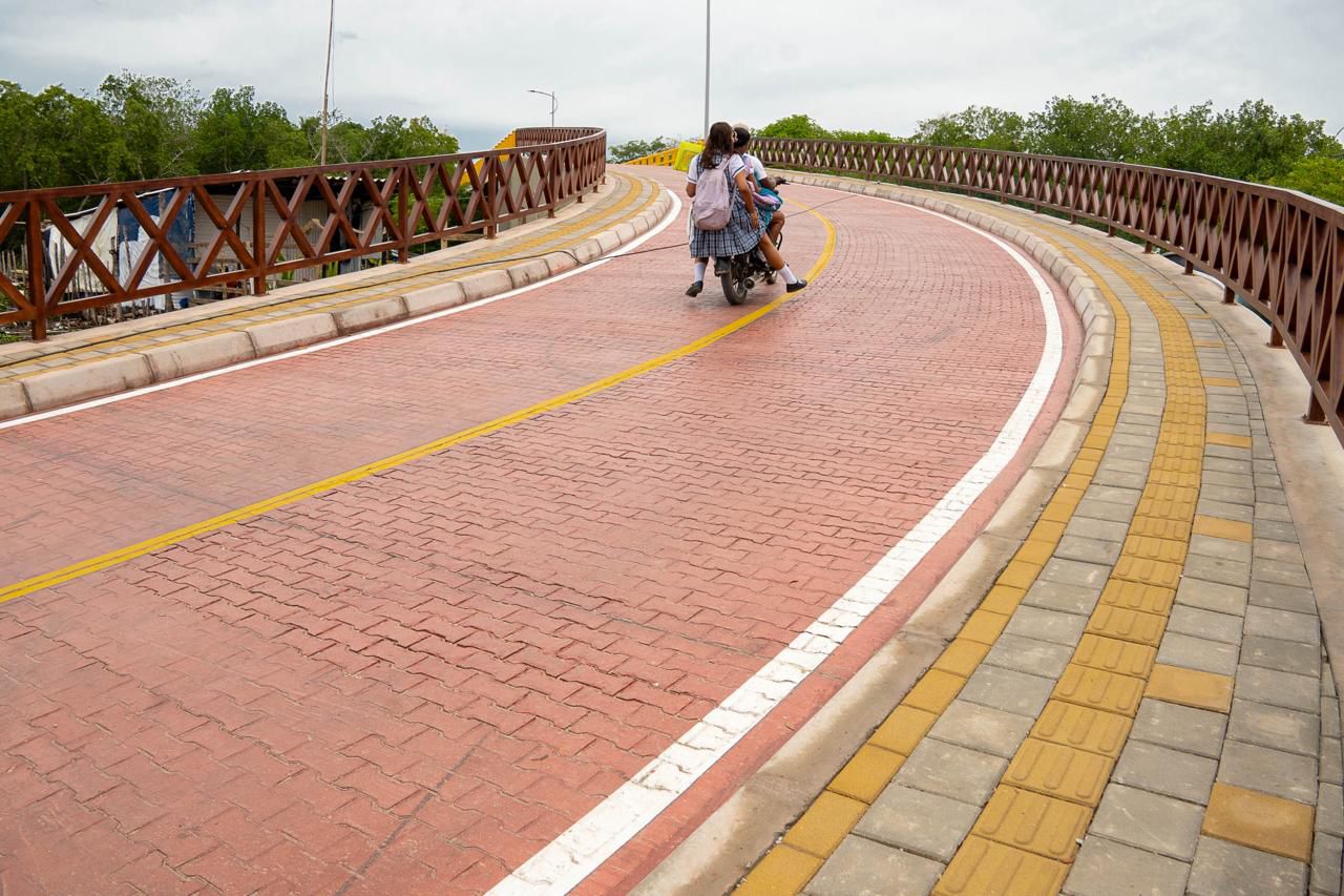 Niñas en moto yendo a la escuela en la vía del Malecón.