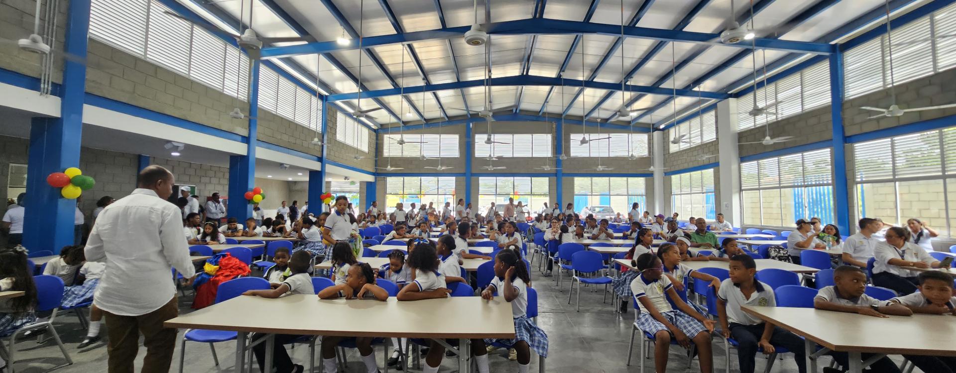 Inaguración de un comedor escolar decorado con decenas de niños.