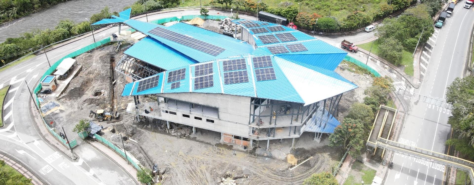 Edificio de tres plantas con techo azul en construcción en medio de una rotonda.