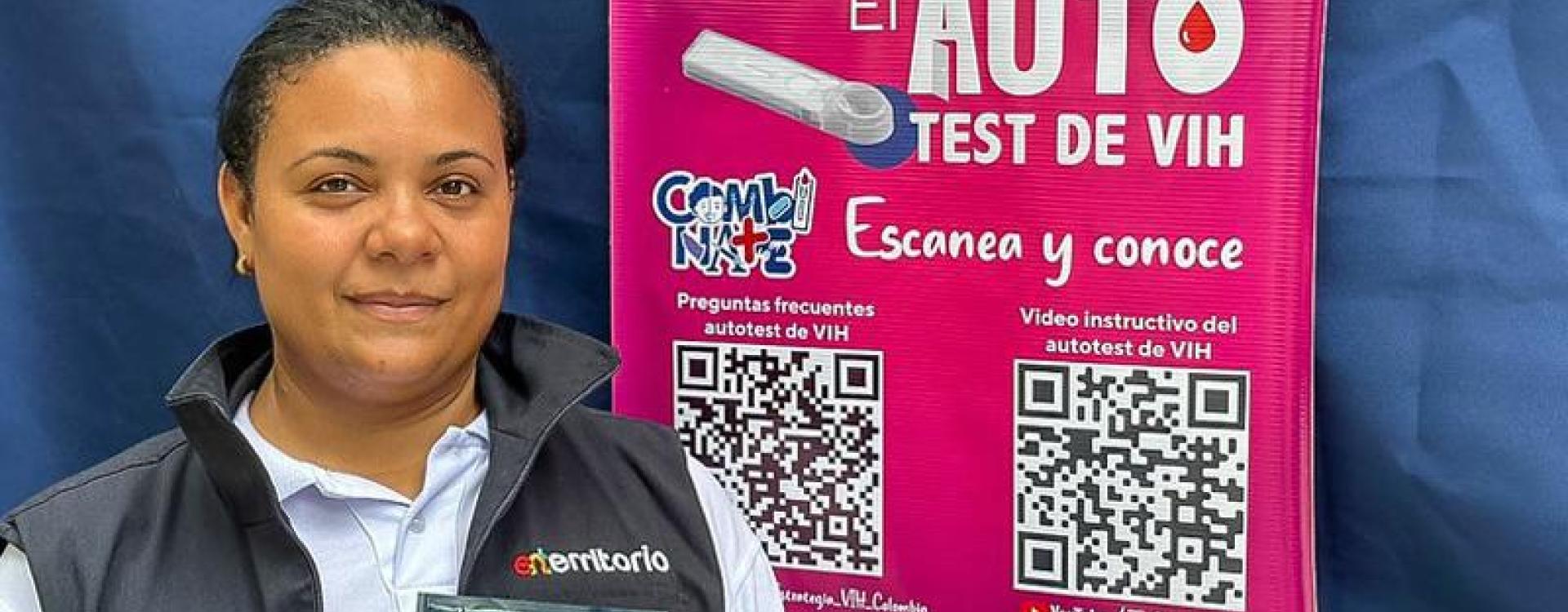 Funcionaria junto a un afiche con información del proyecto de auto test de VIH.