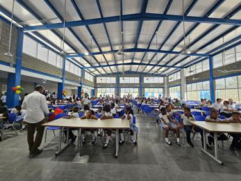 Inaguración de un comedor escolar decorado con decenas de niños.